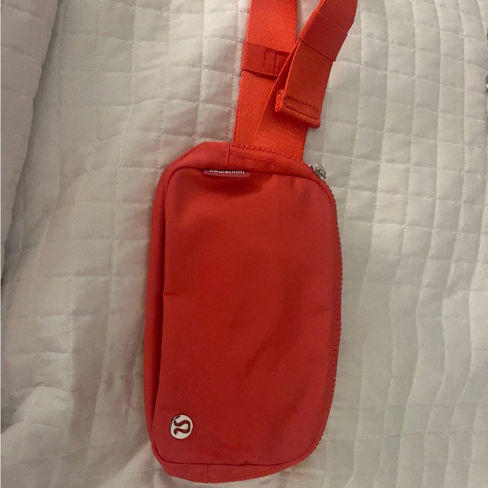 Pink crossbody Lululemon bag with a never lost keychain